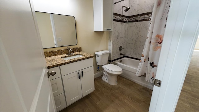 bathroom featuring toilet, shower / bath combo, vanity, wood finished floors, and baseboards