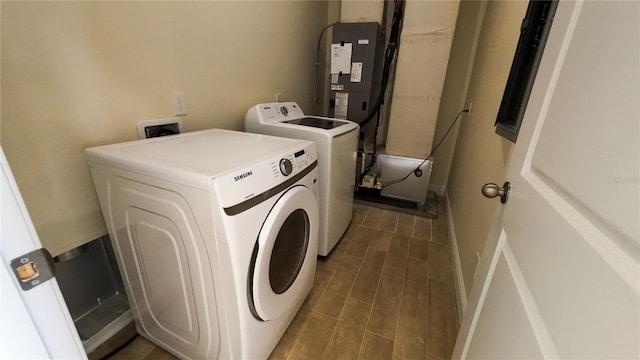 clothes washing area featuring wood tiled floor, laundry area, and washing machine and clothes dryer