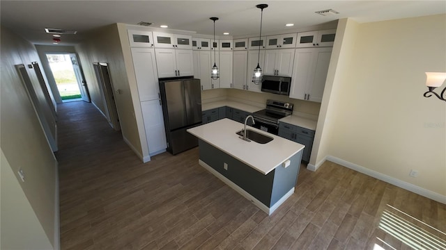 kitchen featuring dark wood-type flooring, a sink, white cabinetry, light countertops, and appliances with stainless steel finishes