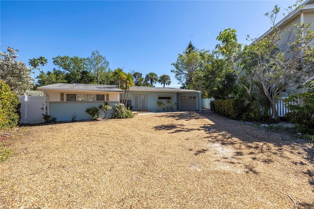 ranch-style home with a garage, driveway, and fence