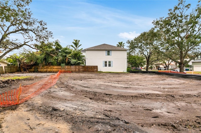 view of side of home with fence and stucco siding