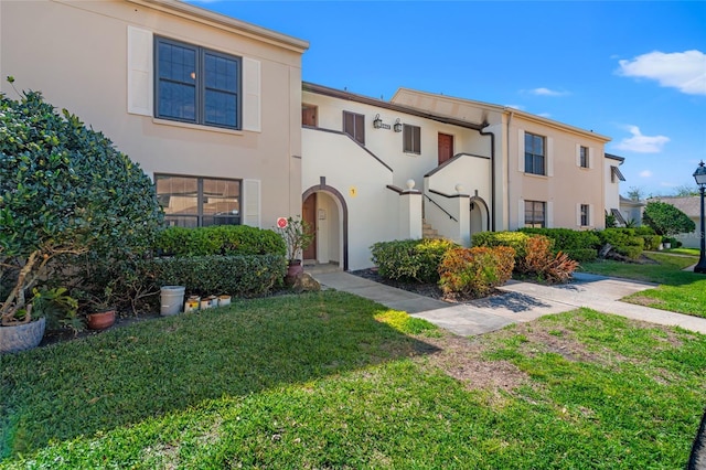 view of front of house featuring a front lawn and stucco siding