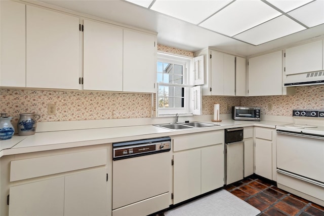 kitchen featuring light countertops, white cabinets, a sink, white appliances, and exhaust hood