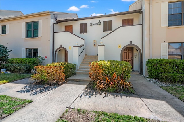 view of property featuring stucco siding and stairs