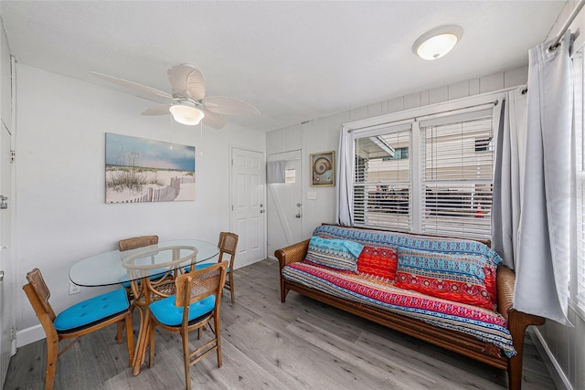 dining space featuring baseboards, a ceiling fan, and wood finished floors