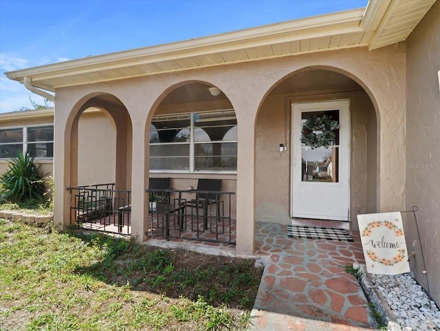 doorway to property featuring stucco siding