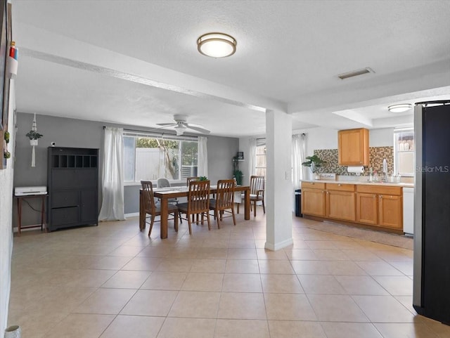 dining area featuring visible vents, a ceiling fan, light tile patterned flooring, a textured ceiling, and baseboards