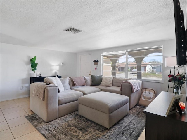 tiled living room featuring visible vents and a textured ceiling