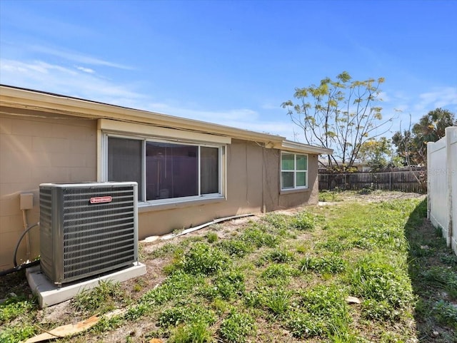 view of home's exterior featuring central AC and fence