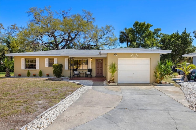 ranch-style home featuring a front lawn, a porch, stucco siding, a garage, and driveway