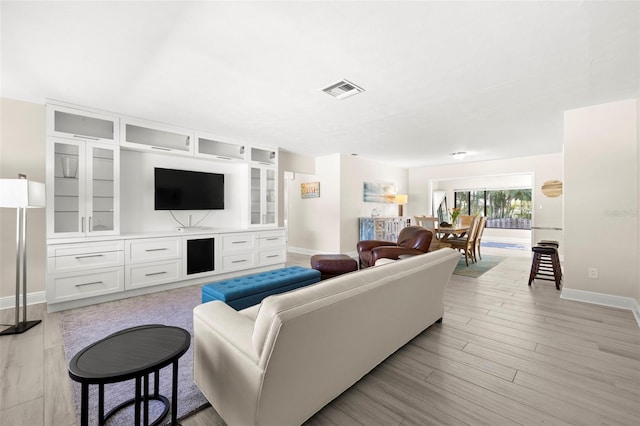 living area with visible vents, baseboards, and light wood-style floors