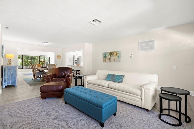 living room featuring visible vents and wood finished floors