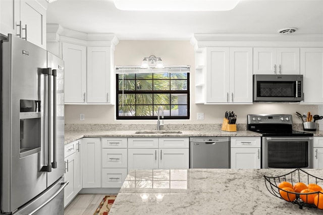 kitchen with light stone counters, visible vents, a sink, stainless steel appliances, and white cabinetry