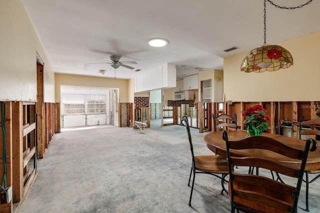 dining space with a ceiling fan, visible vents, and unfinished concrete flooring