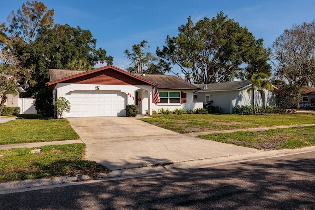 view of front of house featuring a garage, driveway, a front lawn, and stucco siding