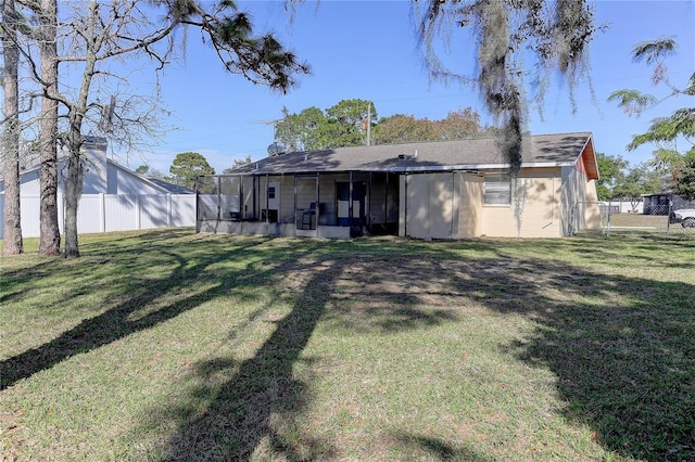 back of property featuring fence and a lawn