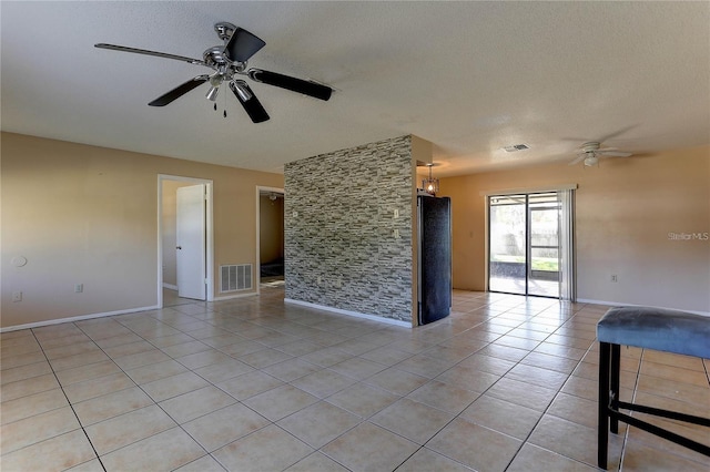 unfurnished room with visible vents, a textured ceiling, and light tile patterned flooring