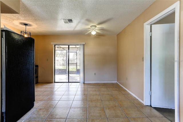 unfurnished room with visible vents, light tile patterned flooring, ceiling fan, a textured ceiling, and baseboards