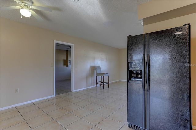 kitchen featuring light tile patterned flooring, black refrigerator with ice dispenser, a textured ceiling, and baseboards