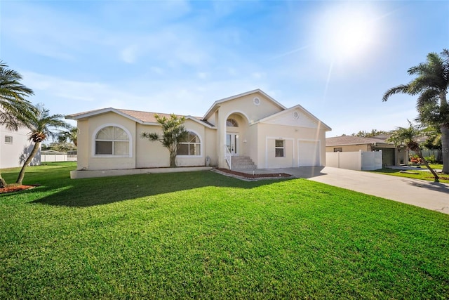 mediterranean / spanish house featuring fence, driveway, an attached garage, stucco siding, and a front lawn