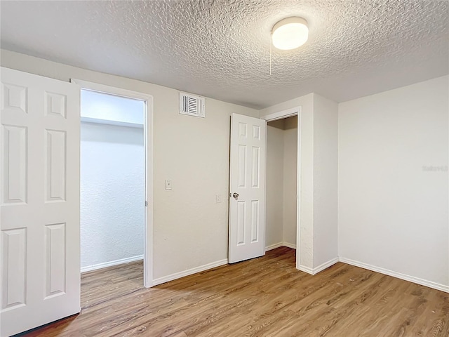 interior space featuring baseboards, visible vents, and wood finished floors