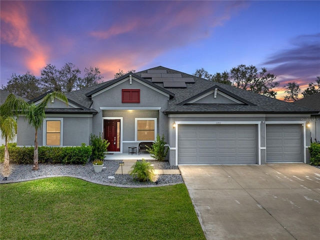 ranch-style house with driveway, solar panels, an attached garage, a front lawn, and stucco siding