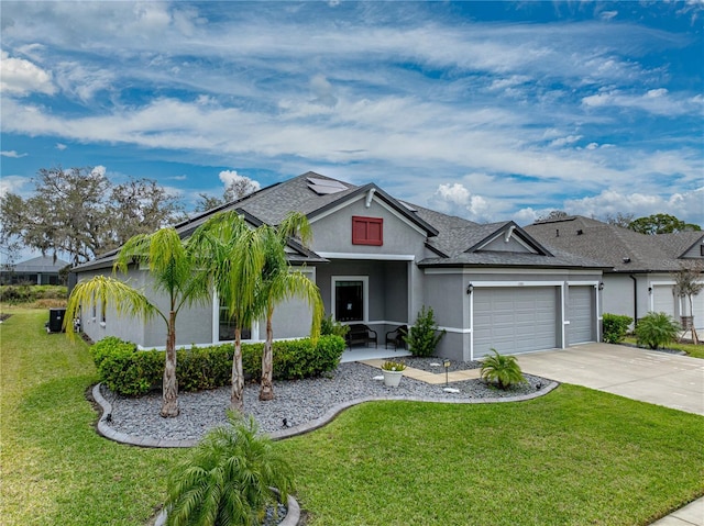 view of front of house with driveway, a garage, a front lawn, and stucco siding