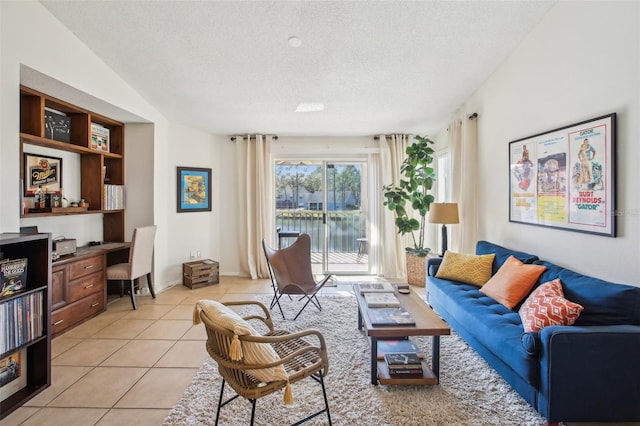 living room featuring light tile patterned floors, a textured ceiling, baseboards, and built in desk