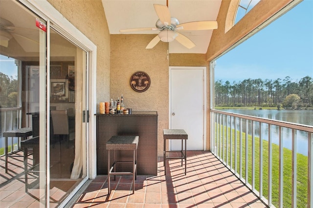 balcony with a sunroom, a water view, and ceiling fan