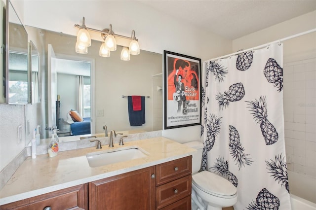 ensuite bathroom featuring shower / tub combo with curtain, connected bathroom, vanity, and toilet