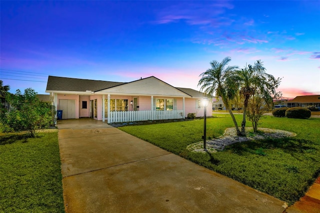 single story home featuring driveway, a porch, and a front yard