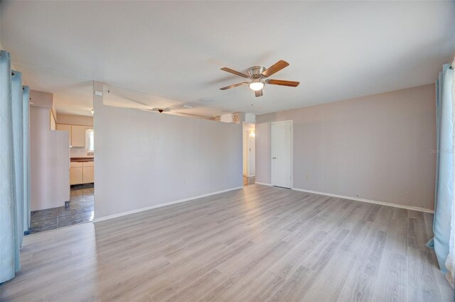 unfurnished room with light wood-style flooring, baseboards, and a ceiling fan