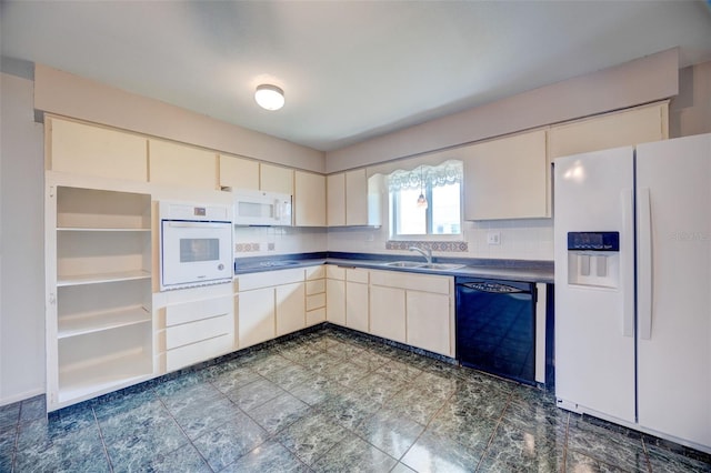 kitchen featuring cream cabinetry, dark countertops, backsplash, a sink, and white appliances