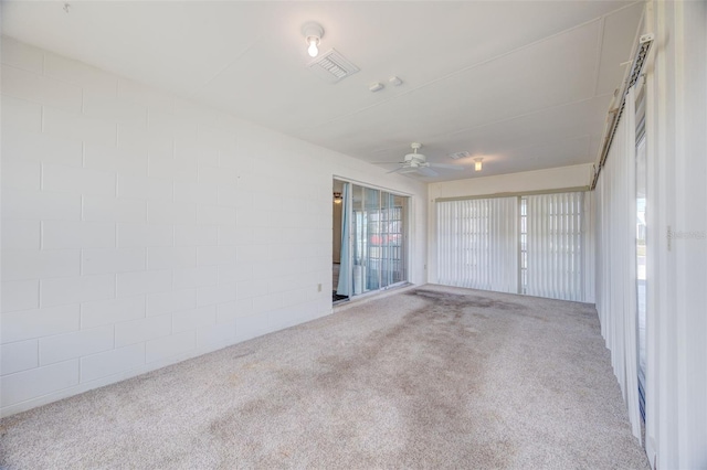 carpeted spare room with visible vents and ceiling fan