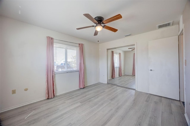 unfurnished bedroom featuring ceiling fan, light wood finished floors, a closet, and visible vents