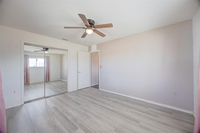 unfurnished bedroom featuring baseboards, visible vents, ceiling fan, and light wood finished floors