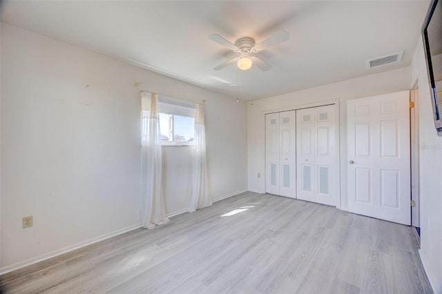 unfurnished bedroom featuring visible vents, baseboards, a ceiling fan, light wood-style floors, and a closet