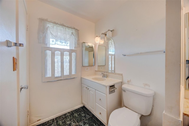 bathroom with vanity, toilet, and baseboards