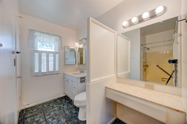 bathroom featuring a shower, vanity, toilet, and baseboards