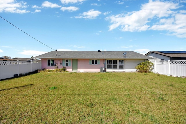 back of property featuring a yard, central AC, and a fenced backyard