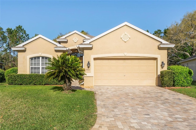 view of front of home with a front yard, decorative driveway, a garage, and stucco siding