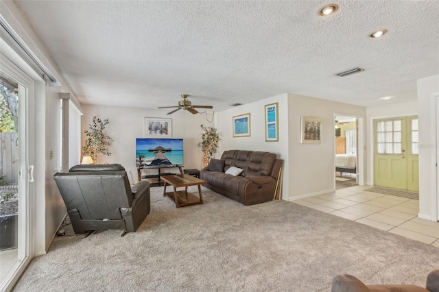 living room with light carpet, a healthy amount of sunlight, light tile patterned floors, and visible vents