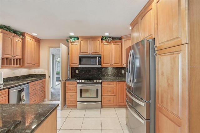 kitchen with light tile patterned floors, stainless steel appliances, recessed lighting, backsplash, and dark stone counters