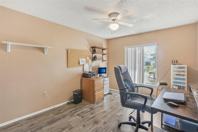 home office with a ceiling fan, a textured ceiling, baseboards, and wood finished floors