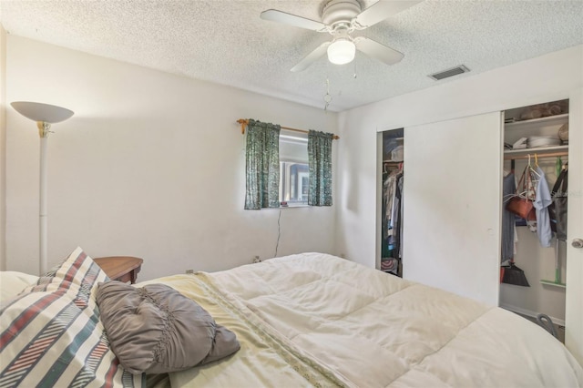 bedroom with a closet, visible vents, ceiling fan, and a textured ceiling