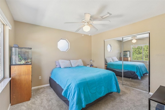 bedroom featuring a closet, visible vents, a ceiling fan, light carpet, and baseboards