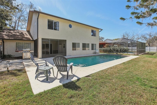 back of house featuring a lawn, a patio area, a fenced in pool, and stucco siding