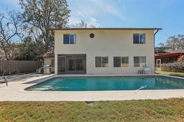 rear view of house with a patio area, fence, a fenced in pool, and stucco siding