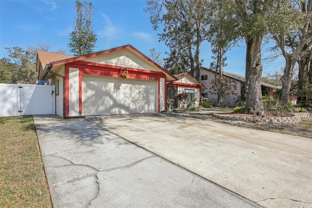 view of front of house featuring a garage, a gate, and concrete driveway