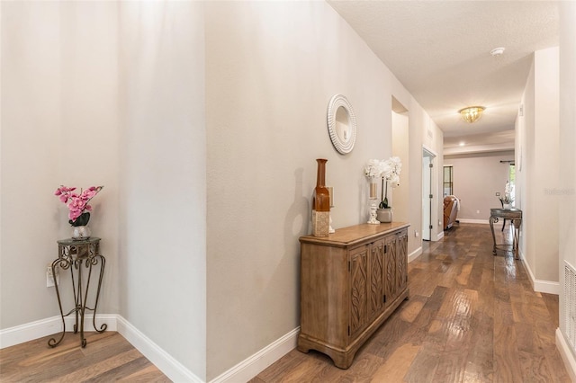 hallway featuring baseboards and wood finished floors